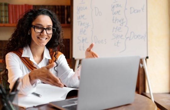 Esta Imagen muestra una profesora en videollamada